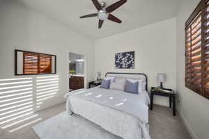 Bedroom with ensuite bathroom, carpet, and ceiling fan