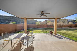 Fenced backyard with ceiling fan, a patio, and outdoor dining space
