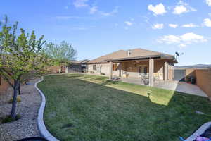 Rear view of house with a fenced backyard, a patio area, a ceiling fan, and stucco siding