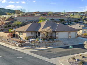 Ranch-style home featuring stone siding, a garage, stucco siding, and driveway
