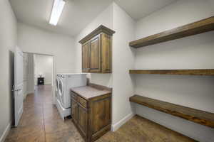 Laundry area featuring cabinet space, separate washer and dryer, and a textured ceiling