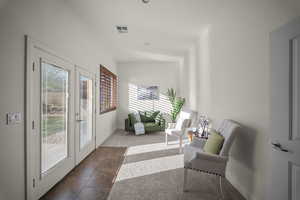 Living area featuring french doors and dark colored carpet
