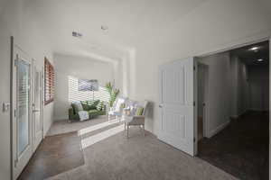 Living area featuring dark carpet and baseboards