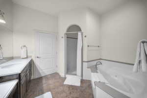 Full bath featuring vanity, a jetted tub, and a shower stall