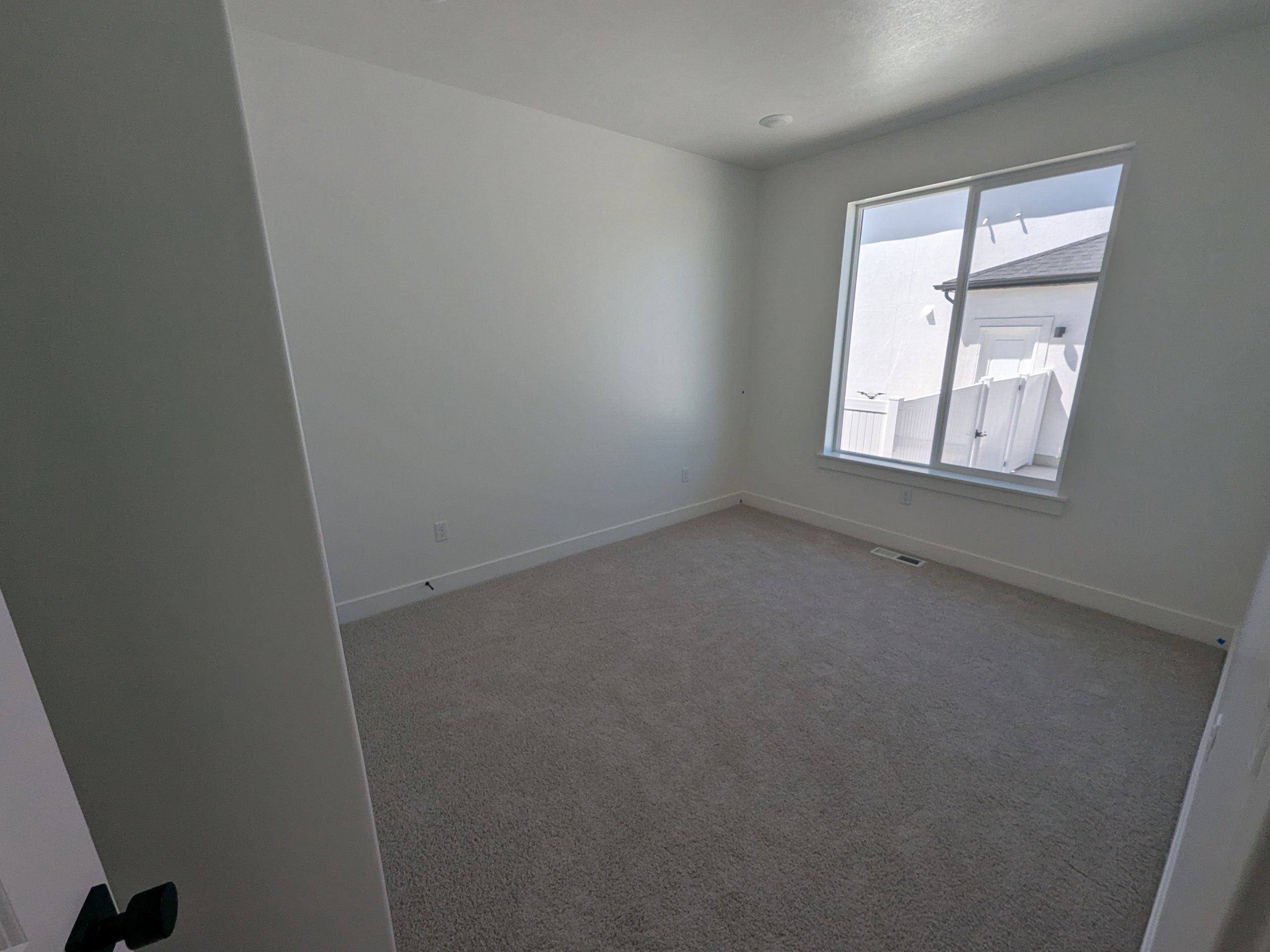 Carpeted empty room with baseboards