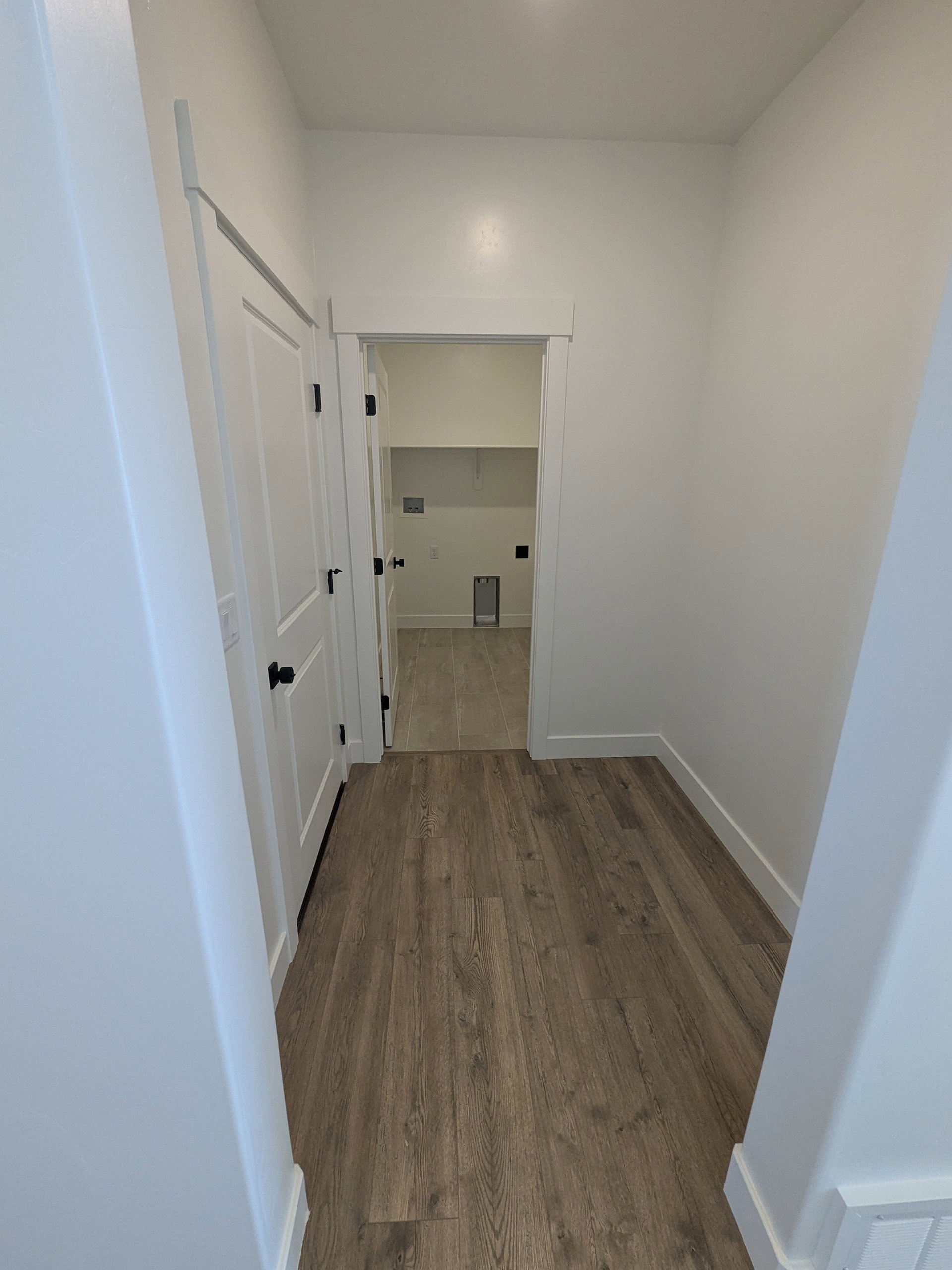 Corridor with dark wood-style floors and baseboards