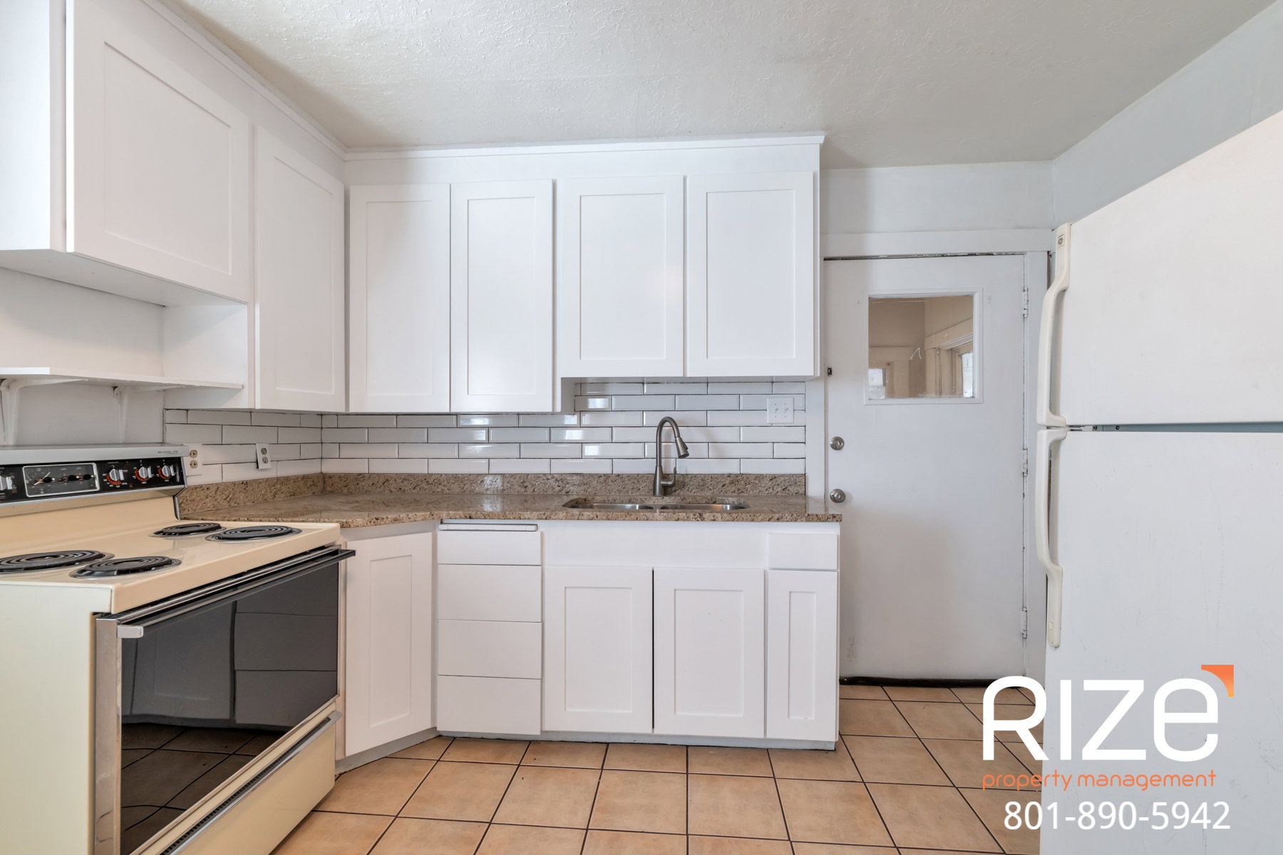 Kitchen with white appliances, white cabinetry, decorative backsplash, light stone countertops, and light tile patterned floors