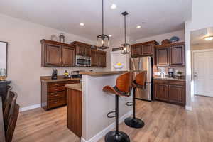 Kitchen with Raised Breakfast Bar, Pantry, and Stainless Steel Appliances
