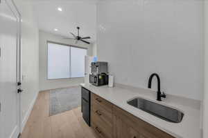 Kitchen with light wood-style floors, freestanding refrigerator, recessed lighting, modern cabinets, and ceiling fan