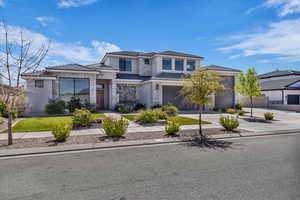 Prairie-style house with driveway, stucco siding, a garage, and stone siding