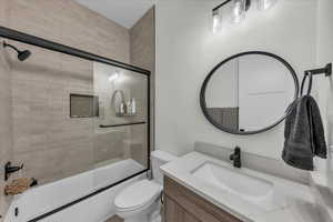Bathroom with vanity and enclosed tub / shower combo