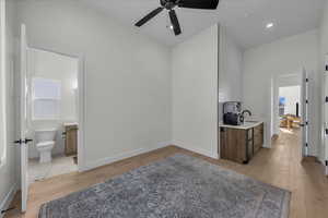 Bar with ceiling fan, light wood finished floors, recessed lighting, and fridge