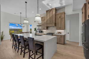 Kitchen featuring a breakfast bar area, light stone countertops, a large island, and stainless steel appliances