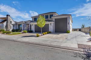 Prairie-style home with concrete driveway, a tiled roof, and stucco siding