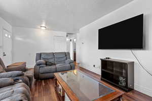 Living room with dark wood-type flooring and a textured ceiling