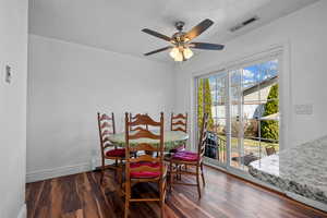 Dining room featuring dark wood-style floors, a ceiling fan, and a textured ceiling