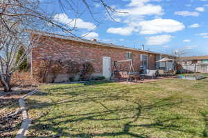 Back of house with brick siding, a patio, and a chimney