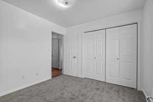 Unfurnished bedroom with a closet, carpet floors, and a textured ceiling