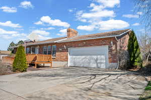 Single story home with concrete driveway, an attached garage, and brick siding