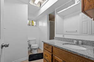 Bathroom with a shower stall, vanity, and light wood-type flooring