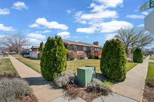 View of home's exterior featuring a yard, brick siding, a chimney, and a residential view