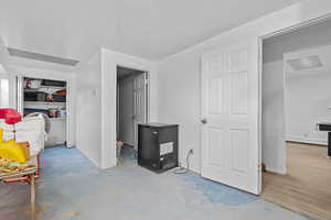 Bedroom featuring unfinished concrete floors, a textured ceiling, and baseboard heating