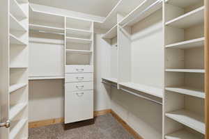 Walk in closet featuring dark carpet