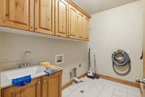 Laundry room featuring hookup for a washing machine, electric dryer hookup, cabinet space, and light floors