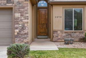 View of exterior entry featuring stone siding and stucco siding