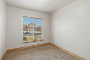 Empty room featuring baseboards and light colored carpet
