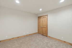 Empty room featuring light carpet, crown molding, and recessed lighting