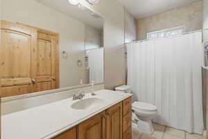 Full bath with vanity, a shower with curtain, and light tile patterned floors