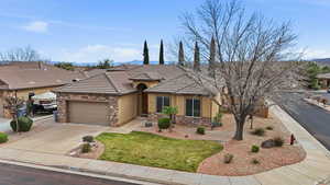 View of front of home with a garage, stucco siding, concrete driveway, and stone siding