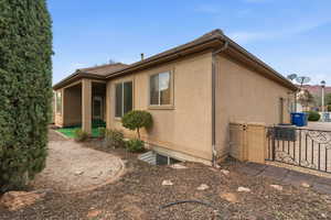 View of side of property featuring stucco siding and a gate