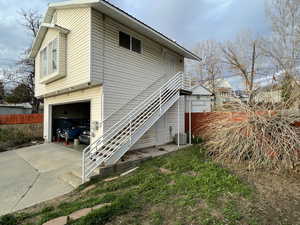 View of side of home featuring a garage and concrete driveway