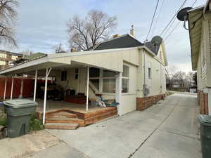 View of side of property with a shingled roof, brick siding, a deck, and crawl space
