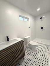 Bathroom with a stall shower, vanity, and recessed lighting