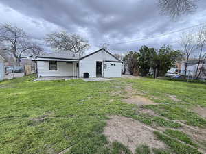 Rear view of house featuring a patio area and a lawn