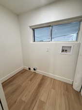 Laundry area with light wood-style flooring and hookup for a washing machine