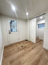 Doorway with wood finished floors and recessed lighting