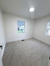 Unfurnished room featuring baseboards and light colored carpet