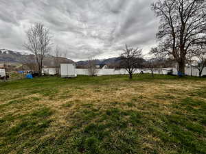 Fenced backyard featuring a mountain view