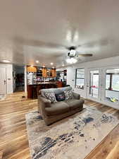 Living room featuring light wood-style flooring, ceiling fan recessed lighting