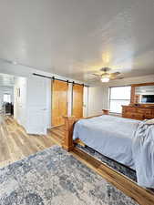Bedroom #1 with a barn door, multiple windows and ceiling fan