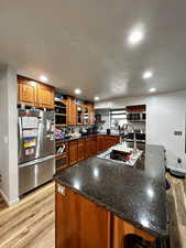 Kitchen featuring open shelves, a kitchen bar, wood finish cabinets, and recessed lighting