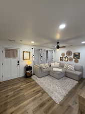 Living area with wood finished floors, ceiling fan, and recessed lighting