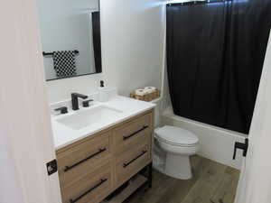 Remodeled Full bathroom featuring vanity, dark wood finished floors, and shower / bath combo