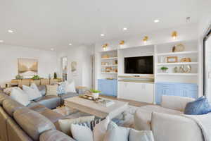 Living room featuring light wood finished floors, recessed lighting, and built in shelves