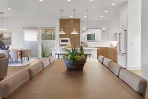 Dining area with hanging lights and light wood finished floors