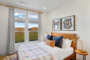 Bedroom with a mountain view, wood finished floors, and recessed lighting